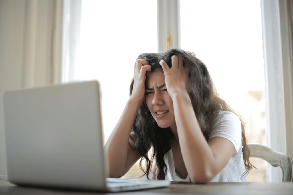 Wypalenie autystyczne kontra wypalenie zawodowe u osób z ADHD/ASD — jak odróżnić i jak wracać do równowagi 🧠 Frustrated woman struggling with remote work stress and digital challenges indoors.